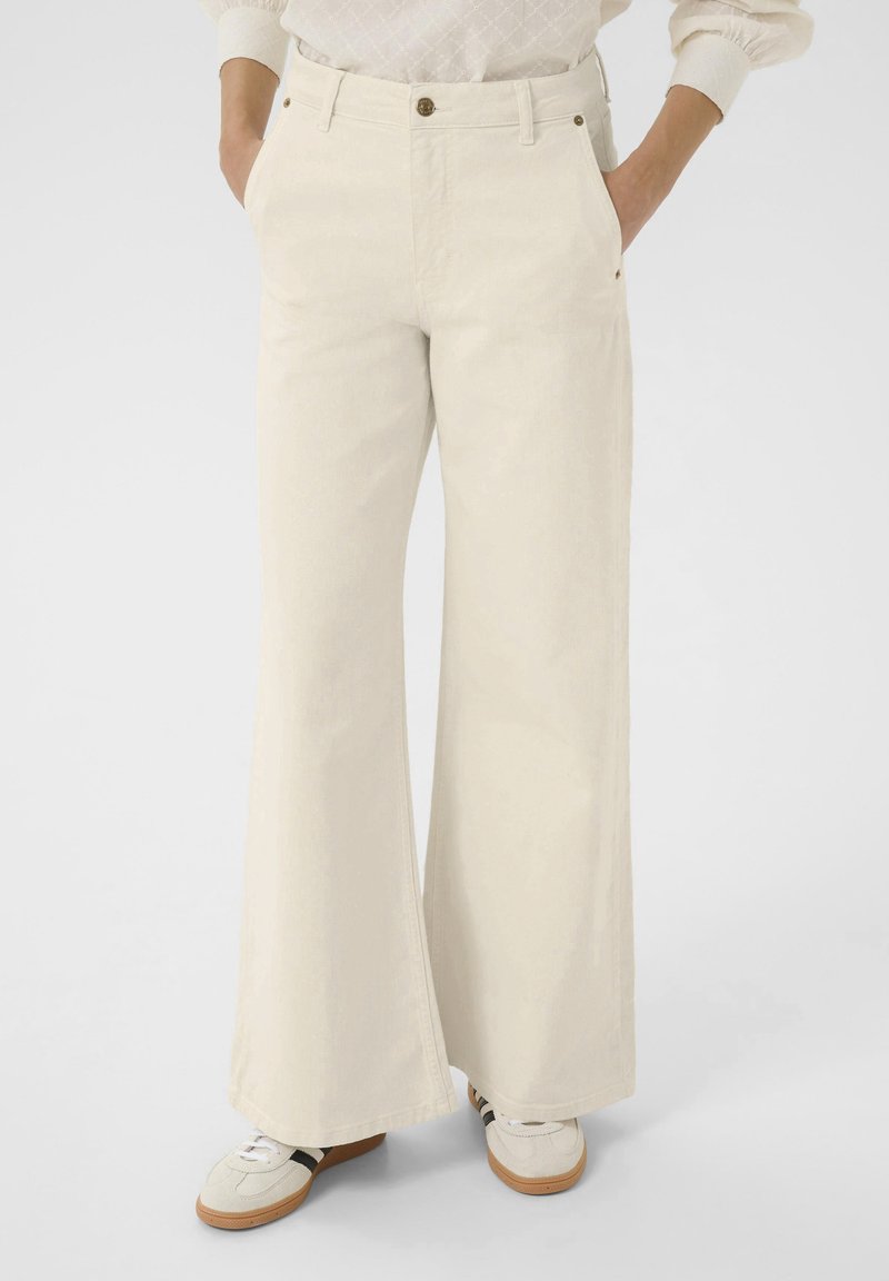 Brede, off-white broek van katoen met een gladde textuur. Voorzien van een hoge taille, voorzakken en gouden metalen accenten.