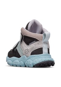 Sneaker nera e grigia con suola blu e etichetta impermeabile. Presenta una fascetta in Velcro e un tessuto testurizzato per grip e comfort.