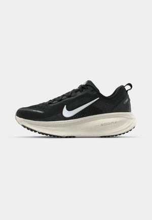 Black Nike running shoe with breathable mesh upper, white swoosh logo, textured detailing, and a cream-colored ZoomX midsole.