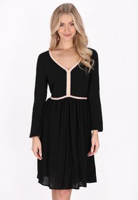 Rochie lungă neagră cu mânecă lungă și decolteu în V, având broderie colorată pe decolteu și talie, fustă lejeră și fluidă, dintr-un material texturat.