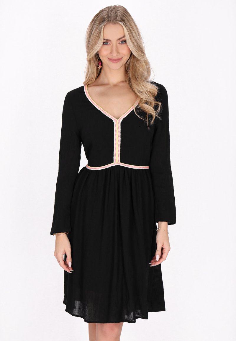 Rochie lungă neagră cu mânecă lungă și decolteu în V, având broderie colorată pe decolteu și talie, fustă lejeră și fluidă, dintr-un material texturat.