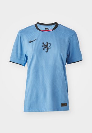 Jersey Nike de color azul claro con mangas cortas, cuello negro y un gráfico de león en el centro. Tejido texturizado con sutiles detalles de canalé.
