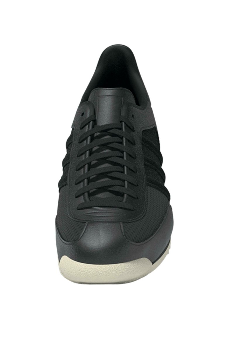 Sort sneaker med en glat læderhætte, mesh-overdel, flade sorte snørebånd og en struktureret sål. Slank profil og minimalistisk design.