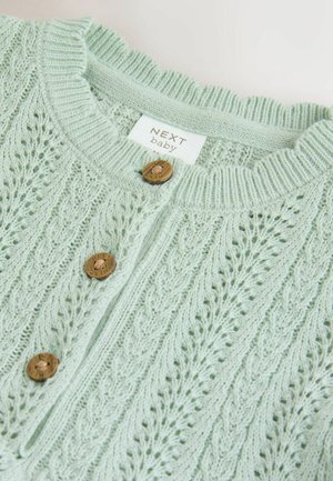 Lys mintgrøn strikket cardigan med et struktureret mønster, bølget krave og træknapper med indgraverede detaljer.