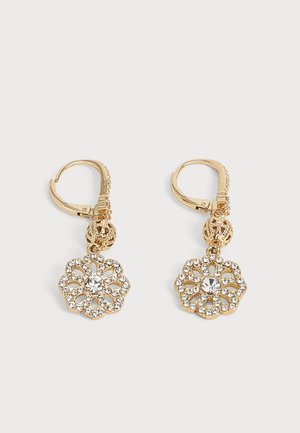 Orecchini a cerchio tono oro con pendenti a forma di fiore in filigrana intricata ornati con strass trasparenti e un cristallo rotondo centrale su sfondo bianco.