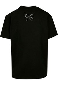 Zwarte katoenen t-shirt met een vlinderontwerp in het wit op de bovenrug. Het shirt heeft korte mouwen en een standaard pasvorm.