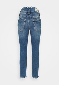 Jean en denim bleu avec une taille mi-haute, coupe slim, deux poches arrière et un ourlet cousu, présentant un délavage subtil et une étiquette au dos.