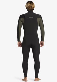 Čierny neoprénový oblek s dlhými rukávmi a vysokým golierom, s tmavozelenými akcentmi na pleciach a po stranách, hladká textúra, priliehavý dizajn.