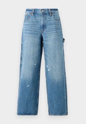 Lyseblå denim cargo jeans med vide ben, blekede sektioner og malingsprut detaljer. Har sidelommer og knappestang.