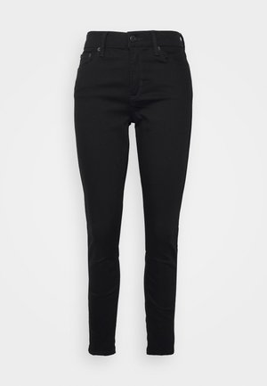 Jean skinny noir taille haute avec bouton et fermeture éclair à l'avant, passants de ceinture, ainsi que poches latérales et arrière, présenté sur un fond uni.