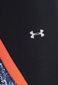 Svart atletisk tyg med en orange accent och ett texturerat blått mönster. Innehåller en liten vit logotyp i den övre delen.