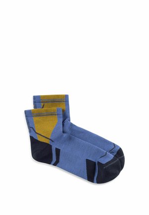 Pair of ankle-length socks in blue with black toes and heels, featuring mustard yellow geometric patterns on the upper sides.