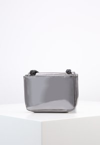 Borsa elegante grigia con una forma rettangolare, caratterizzata da dettagli annodati sulle maniglie e una texture liscia. Design minimalista.