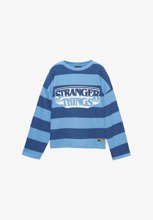 Modrá košeľa s dlhým rukávom a širokými horizontálnymi pruhmi, s textovým logom "STRANGER THINGS" umiestneným na strede hrude.