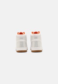 Bílé vysoké tenisky mají síťovaný svršek, oranžové akcenty na límci a podrážku z gumové pryže. Hladký povrch s zesíleným švem.