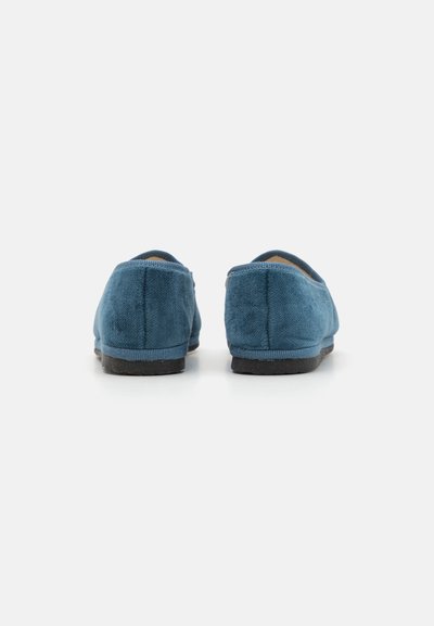 Blå semsket slip-on sko med runde bakker, minimal søm og en flat svart gummisåle. Myk tekstur, enkel design.