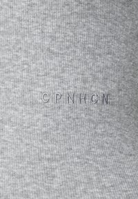 Grey ribbed fabric featuring the embroidered text "CPNHGN" in a slightly darker shade. Smooth texture with vertical lines.