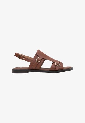 Brown leather flat sandal with three gold-tone buckles and open sides, featuring a slingback strap and black sole.