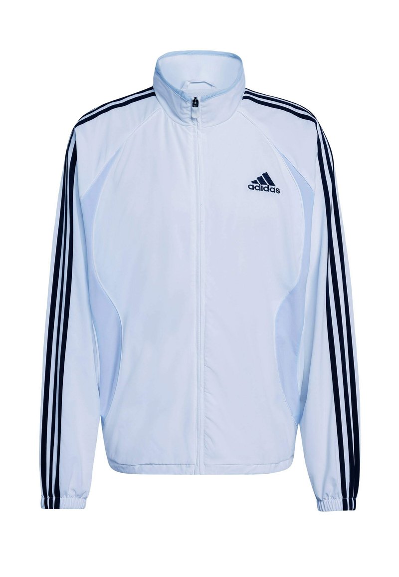 Veste de sport blanche avec design à trois bandes bleu marine sur les manches, col montant, fermeture éclair et matériau léger. Comprend le logo Adidas.
