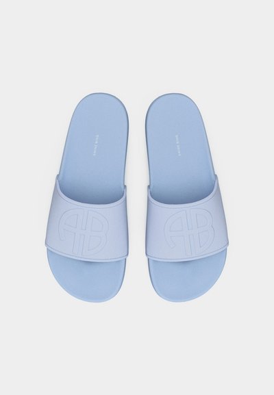 Sandales à glissière bleu clair avec logo "AB" en relief sur les larges brides et texte "Anine Bing" sur les semelles, vues de dessus.