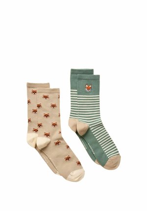Two pairs of socks, one beige with small fox faces, one green with beige stripes and a single fox face near the cuff.