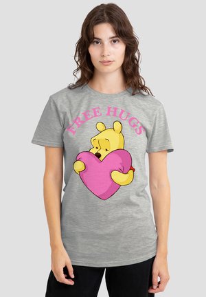 Gray cotton t-shirt featuring a cartoon bear holding a pink heart, with the text "FREE HUGS" in bold pink above the graphic.