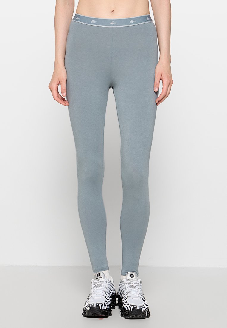 Leggings azul claro con un diseño ajustado, hechos de una tela suave, con una cinturilla de marca y una textura lisa.