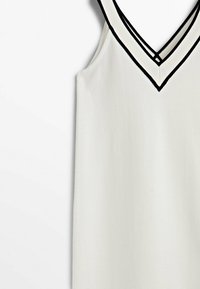 Weißes ärmelloses Kleid mit V-Ausschnitt, verziert mit schwarzem Saum entlang der Kanten. Glattes, strukturiertes Material ohne sichtbare Muster.