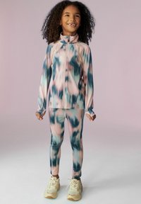 Sada sportovního oblečení ze dvou kusů, která obsahuje bundu na zip a odpovídající legíny. Látka má vícebarevný tie-dye vzor v pastelových odstínech.