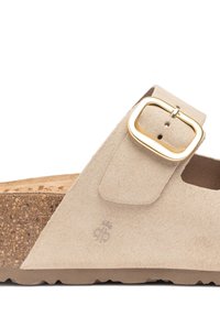 Sandalo in suede beige con suola spessa in sughero, dotato di una fascia larga e fibbia in metallo dorato per la regolazione. Superficie testurizzata e design piatto.