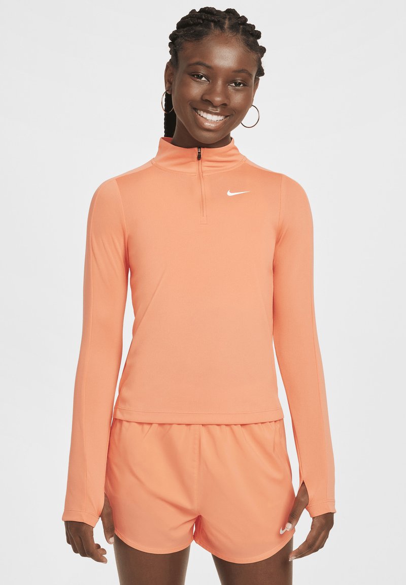 Langärmliges Sportoberteil in leuchtendem Orange mit einem Viertelreißverschluss und Nike-Logo. Weicher, dehnbarer Stoff, kombiniert mit passenden Shorts.