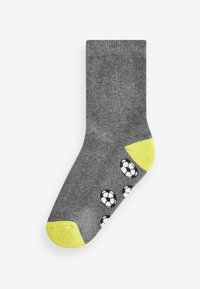 Graue Baumwollsocke mit strukturierter Strickware, gelben Akzenten an Spitze und Ferse sowie weißen Fußballmustern an der Seite.