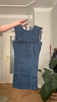 Farmernadrág ruha kerek kivágással és kék textúrával. A négyzet alakú yoke kiemeli, oldalzsebekkel rendelkezik, és testhez simuló siluettet alkot.