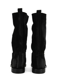 Stivali alti neri in suede con una texture liscia, punta arrotondata e tacco basso. Presentano cuciture verticali e linguette di aggancio nella parte superiore.