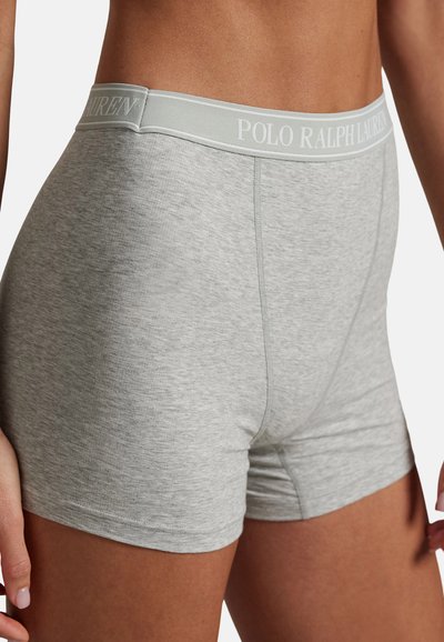 Κοντινό πλάνο ενός ατόμου που φοράει ανοιχτό γκρι μποξεράκια με ελαστική ζώνη μέσης με το εμπορικό σήμα "POLO RALPH LAUREN."