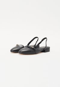 Chaussures slingback noires en cuir avec des pointes effilées, des talons blocs bas et une sangle décorative avec un petit accent doré.
