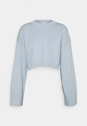Pull court bleu clair avec un col rond, des manches longues et des poignets côtelés. Fabriqué à partir d'un matériau doux et texturé.