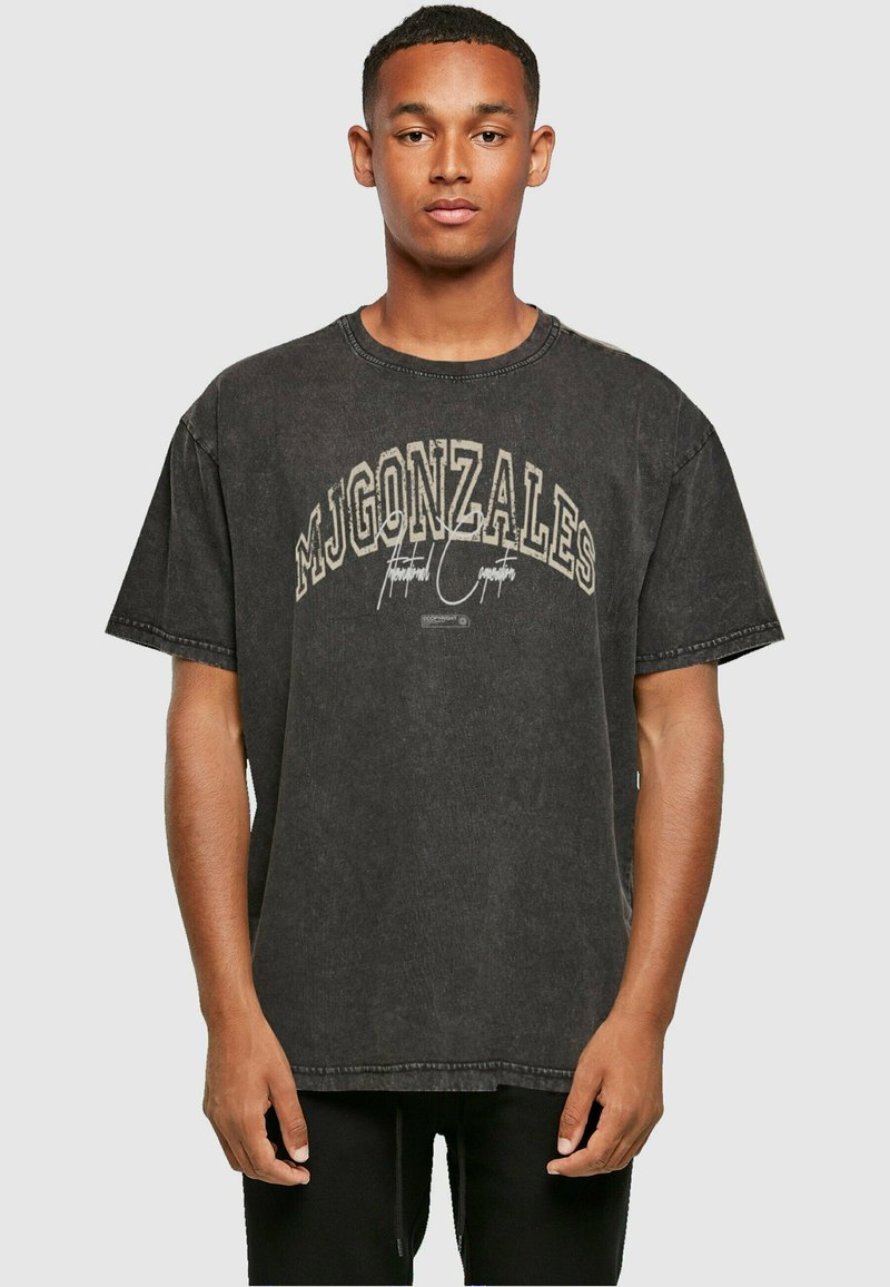 Svart oversized bomull t-skjorte med rund hals, med fet hvit tekst "MJGONZALES" og grafiske detaljer på forsiden.