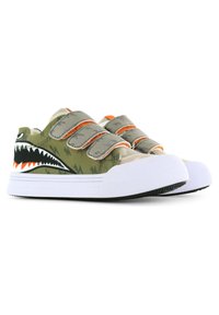 Groene canvas sneakers met een haaientandenontwerp, klittenbandsluitingen en witte rubberen zolen. Voorzien van oranje accenten en textuurdetails.