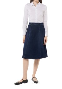 Denim A-Linien-Rock in dunkelblauer Nuance, mit hoher Taille, sauberer Naht und glatter Textur, kombiniert mit schwarzen flachen Schuhen.