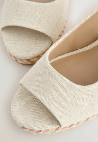 Bézs színű, nyitott orrú espadrille szandálok, texturált szövet felsőrésszel és természetes valamint puhán rózsaszín árnyalatú fonott zsúptalp részletekkel.