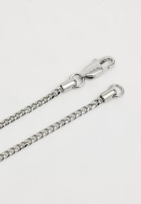 Ασημένια αλυσίδα με αλληλοσυνδεόμενους κρίκους, η οποία διαθέτει κούμπωμα και δαχτυλίδια για προσαρμογή. Λειαντική υφή, γυαλισμένη επιφάνεια και ελαφρύ σχέδιο.