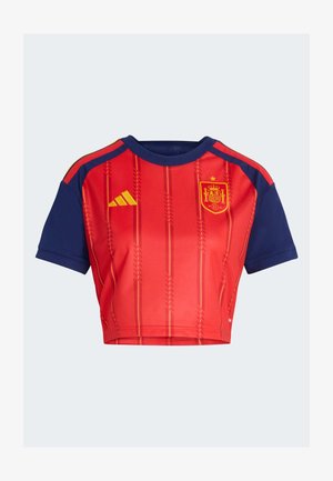 Kratka nogometna majica u crvenoj i tamnoplavoj boji s okomitih pruga, grbom španjolske nacionalne momčadi na desnoj strani prsa i žutim Adidas logotipom na lijevoj strani prsa.