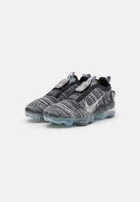 Black and gray knit athletic shoes with a translucent sole, featuring a textured pattern, pull tabs, and a lacing system for adjustment.
