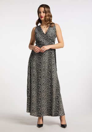 Maxikjole i sort og creme leopardprint, med en indpakningsdesign, v-udskæring og uden ærmer. Kompletteret med sorte højhælede sko.