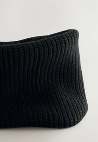 Bonnet en tricot noir à côtes ; tissu en maille doux et texturé ; forme tubulaire ; présente des lignes verticales ; sans logos visibles ni accents en métal.