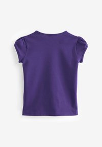T-shirt violet à manches bouffantes courtes, col rond et texture en coton lisse. Le fond est blanc uni.