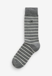 Chaussette en coton rayée grise avec des rayures horizontales blanches, une bande côtelée à la cheville et un petit logo noir près de la cheville.