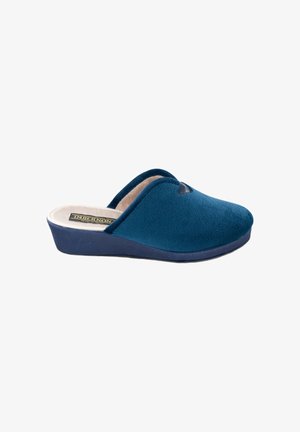 Zapatilla azul sin cordones con exterior de tejido suave, interior acolchado beige y suela baja con cuña diseñada para la comodidad en interiores.