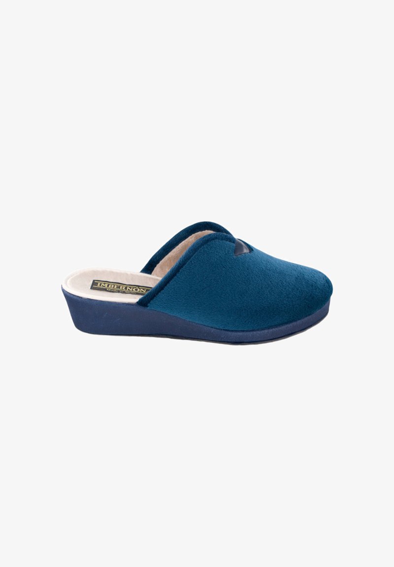 Zapatilla azul sin cordones con exterior de tejido suave, interior acolchado beige y suela baja con cuña diseñada para la comodidad en interiores.